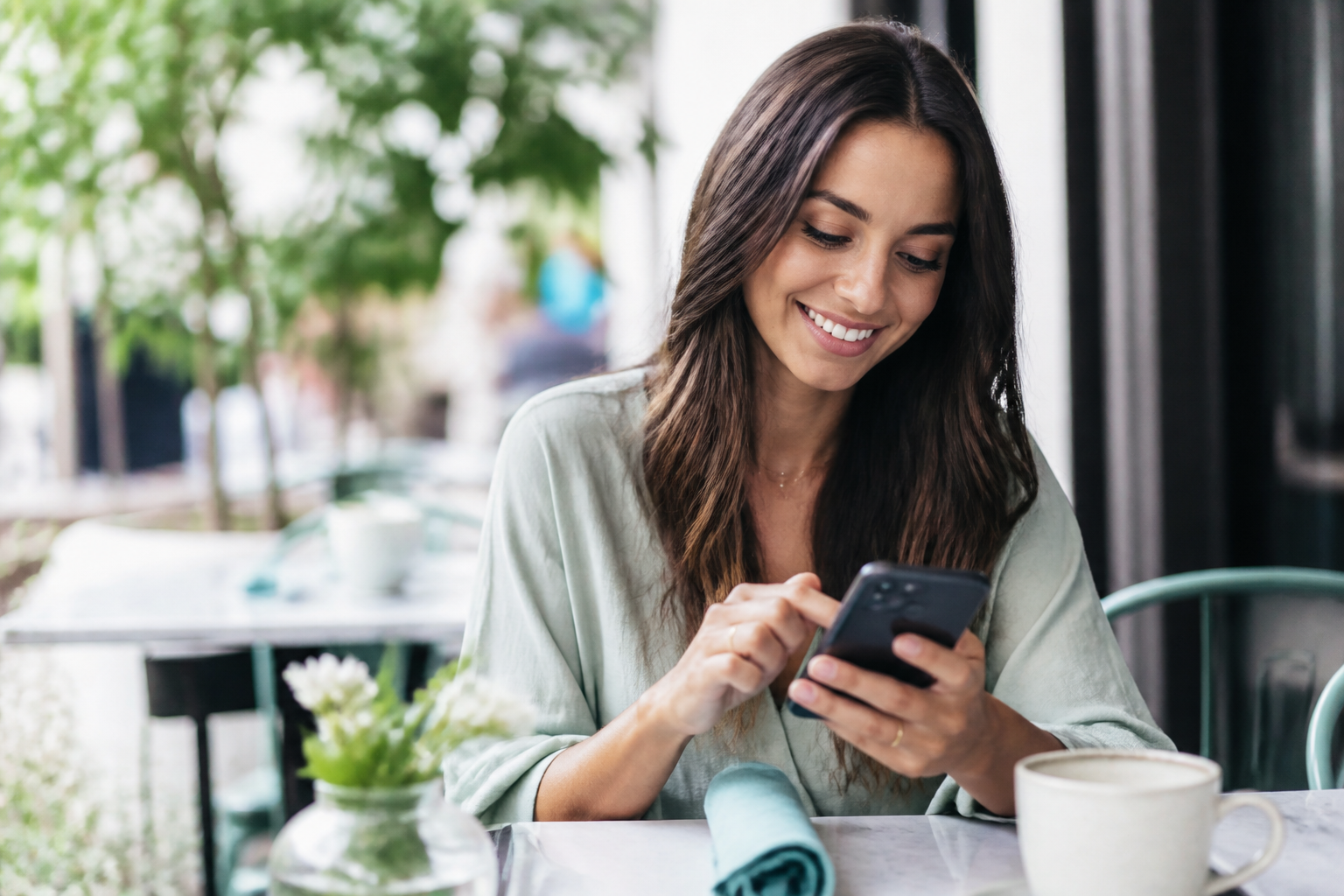 Person replying to a message on a phone at a cafe